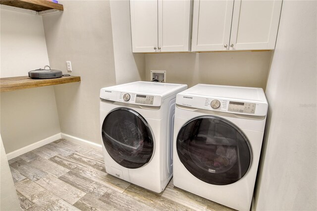 11502 Golden Bay Pl, Bradenton, FL 34211 - washroom featuring separate washer and dryer, light wood-style floors, cabinet space, and baseboards