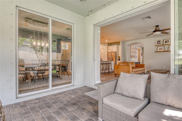 11502 Golden Bay Pl, Bradenton, FL 34211 - living area with arched walkways, a ceiling fan, and brick flooring