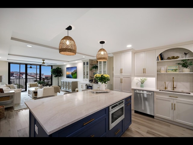 2045 Gulf Of Mexico Dr Unit M1-505, Longboat Key, FL 34228 - kitchen featuring stainless steel appliances, a sink, blue cabinetry, open shelves, and white cabinetry
