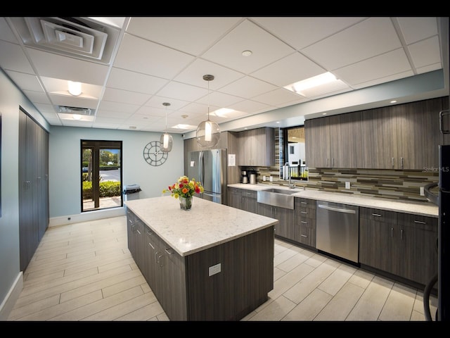 2045 Gulf Of Mexico Dr Unit M1-505, Longboat Key, FL 34228 - kitchen with stainless steel appliances, a sink, a kitchen island, a paneled ceiling, and baseboards