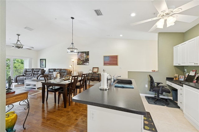 7532 Marsh Orchid Cir Unit 8-201, Bradenton, FL 34203 - kitchen featuring ceiling fan, a sink, dark countertops, white cabinets, and vaulted ceiling