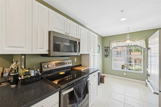 7532 Marsh Orchid Cir Unit 8-201, Bradenton, FL 34203 - kitchen featuring appliances with stainless steel finishes, white cabinets, dark countertops, and baseboards