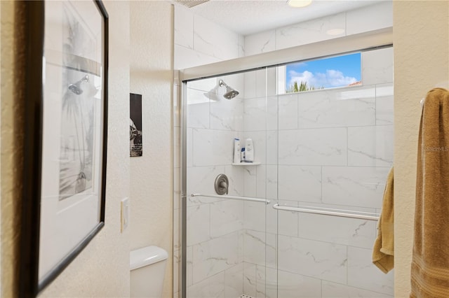 7532 Marsh Orchid Cir Unit 8-201, Bradenton, FL 34203 - full bathroom with toilet, a stall shower, and a textured wall