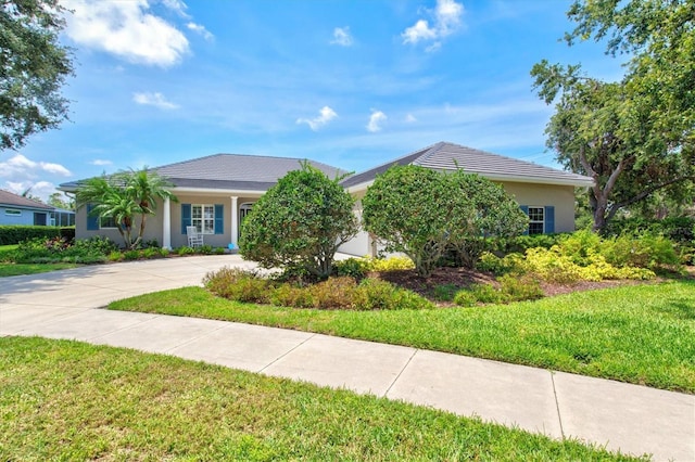 5373 Anthony Ln, Sarasota, FL 34233 - view of front facade with concrete driveway, a front yard, stucco siding, and an attached garage