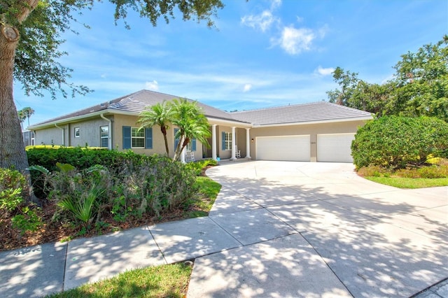 5373 Anthony Ln, Sarasota, FL 34233 - ranch-style house with a garage, concrete driveway, stucco siding, and a tile roof
