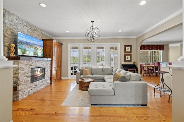 5373 Anthony Ln, Sarasota, FL 34233 - living area featuring a stone fireplace, crown molding, light wood-style flooring, recessed lighting, and a chandelier