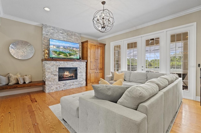 5373 Anthony Ln, Sarasota, FL 34233 - living room featuring a chandelier, a fireplace, light wood finished floors, ornamental molding, and french doors
