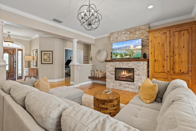 5373 Anthony Ln, Sarasota, FL 34233 - living area with light wood-style floors, baseboards, ornamental molding, a stone fireplace, and a chandelier