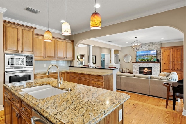 5373 Anthony Ln, Sarasota, FL 34233 - kitchen featuring a sink, arched walkways, appliances with stainless steel finishes, decorative columns, and recessed lighting