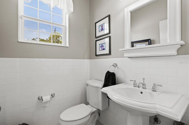 5373 Anthony Ln, Sarasota, FL 34233 - bathroom featuring toilet, tile walls, wainscoting, and a sink