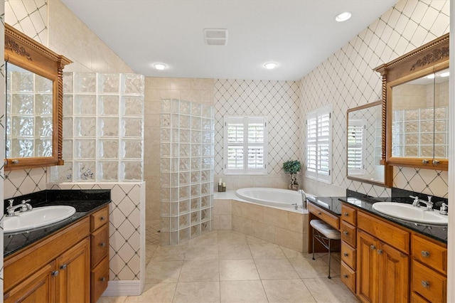 5373 Anthony Ln, Sarasota, FL 34233 - full bathroom featuring tile walls, a bath, two vanities, walk in shower, and tile patterned flooring
