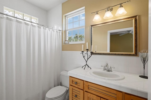 5373 Anthony Ln, Sarasota, FL 34233 - full bath featuring vanity, toilet, tile walls, a shower with curtain, and a ceiling fan