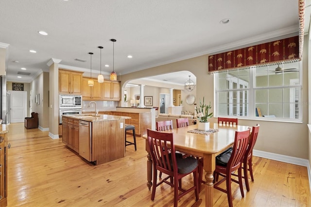 5373 Anthony Ln, Sarasota, FL 34233 - dining room featuring arched walkways, crown molding, baseboards, light wood-style flooring, and recessed lighting