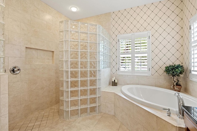 5373 Anthony Ln, Sarasota, FL 34233 - bathroom featuring a bath, a walk in shower, tile patterned floors, and tile walls