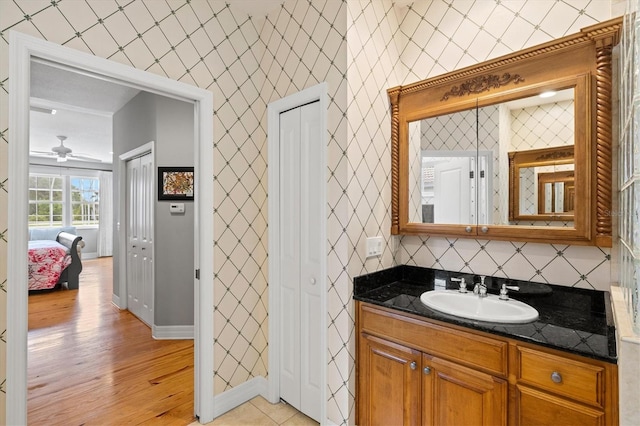 5373 Anthony Ln, Sarasota, FL 34233 - bathroom featuring vanity, wood finished floors, a ceiling fan, baseboards, and decorative backsplash