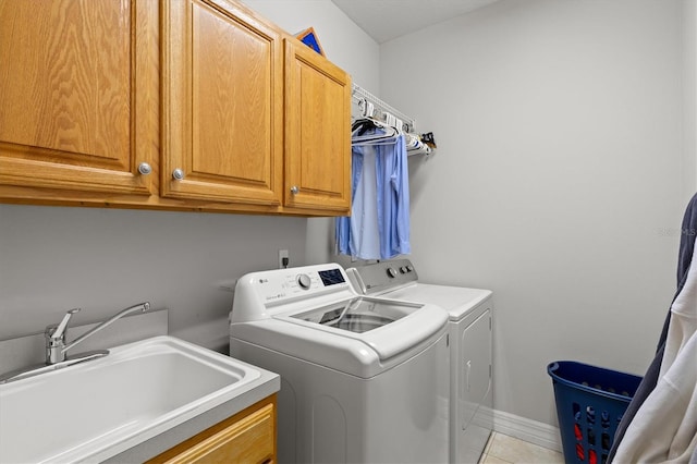 5373 Anthony Ln, Sarasota, FL 34233 - laundry room with cabinet space, washing machine and clothes dryer, light tile patterned flooring, and baseboards