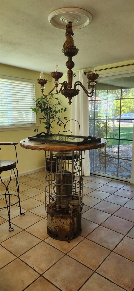219 24th St W, Bradenton, FL 34205 - dining space featuring light tile patterned floors, baseboards, and a textured ceiling