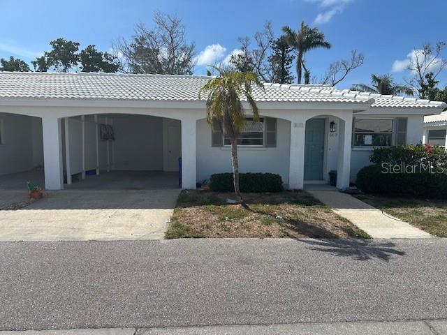 669 Spanish Dr N Unit 21, Longboat Key, FL 34228 - ranch-style house featuring concrete driveway, a tiled roof, stucco siding, and an attached carport