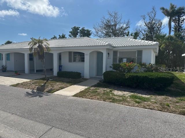 669 Spanish Dr N Unit 21, Longboat Key, FL 34228 - ranch-style house with a tile roof, concrete driveway, and stucco siding