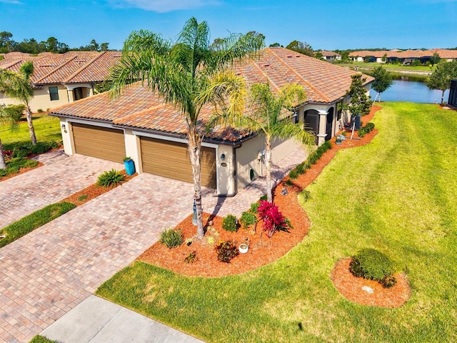 12230 Amica Loop, Venice, FL 34293 - mediterranean / spanish-style house featuring a tile roof, stucco siding, decorative driveway, a front yard, and a garage