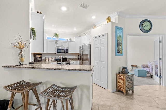 12230 Amica Loop, Venice, FL 34293 - kitchen featuring appliances with stainless steel finishes, a peninsula, ornamental molding, a breakfast bar area, and light stone countertops