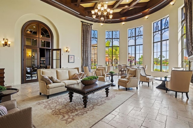 12230 Amica Loop, Venice, FL 34293 - living area featuring a high ceiling, a chandelier, stone tile floors, beam ceiling, and coffered ceiling
