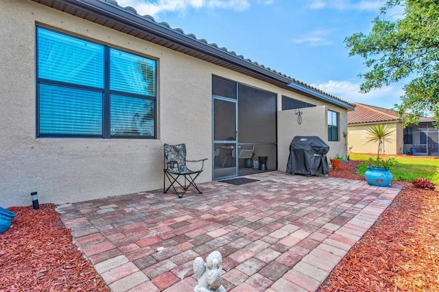 12230 Amica Loop, Venice, FL 34293 - view of patio featuring a grill and a sunroom
