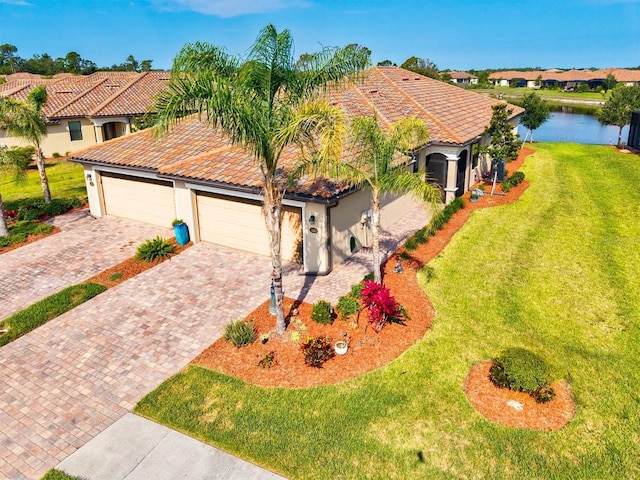 12230 Amica Loop, Venice, FL 34293 - mediterranean / spanish house featuring a tiled roof, stucco siding, decorative driveway, a front yard, and a garage