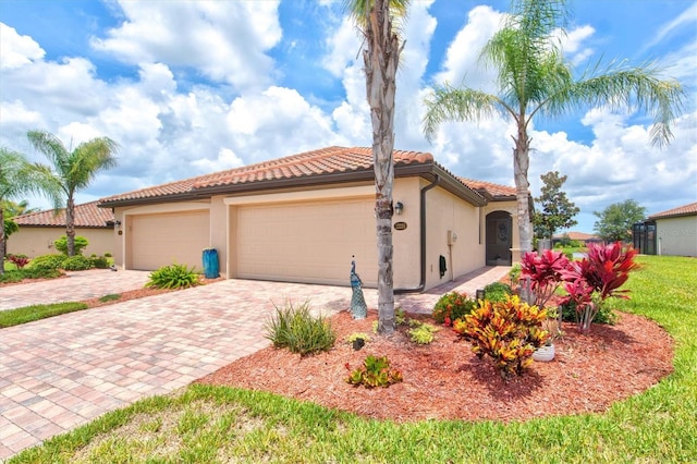 12230 Amica Loop, Venice, FL 34293 - mediterranean / spanish-style home with stucco siding, decorative driveway, a tiled roof, and an attached garage