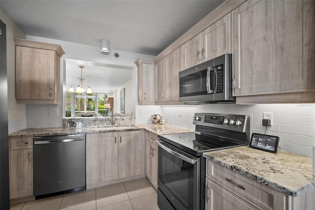 4530 Pinebrook Cir Unit 109, Bradenton, FL 34209 - kitchen featuring stainless steel appliances, light brown cabinetry, a sink, a chandelier, and decorative backsplash