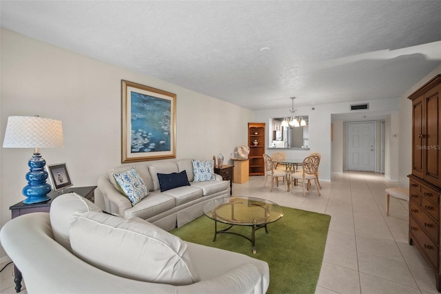 4530 Pinebrook Cir Unit 109, Bradenton, FL 34209 - living room with a chandelier, light tile patterned floors, and a textured ceiling