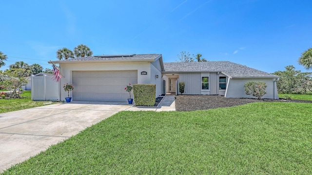 4308 Kingston Loop, Sarasota, FL 34238 - ranch-style house featuring roof mounted solar panels, an attached garage, driveway, and a front lawn