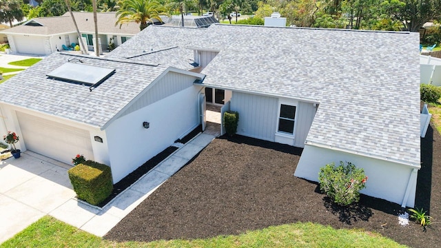 4308 Kingston Loop, Sarasota, FL 34238 - view of front facade featuring a shingled roof, concrete driveway, and a garage