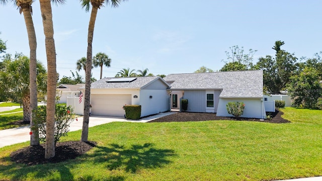 4308 Kingston Loop, Sarasota, FL 34238 - view of front of house featuring an attached garage, driveway, roof mounted solar panels, and roof with shingles