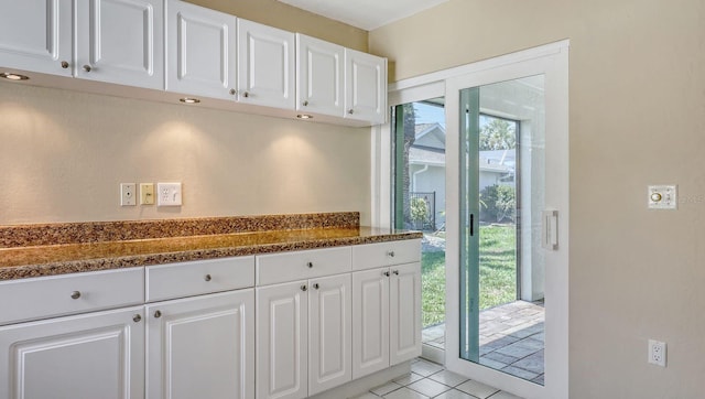 4308 Kingston Loop, Sarasota, FL 34238 - kitchen with white cabinetry, light tile patterned floors, and dark stone countertops