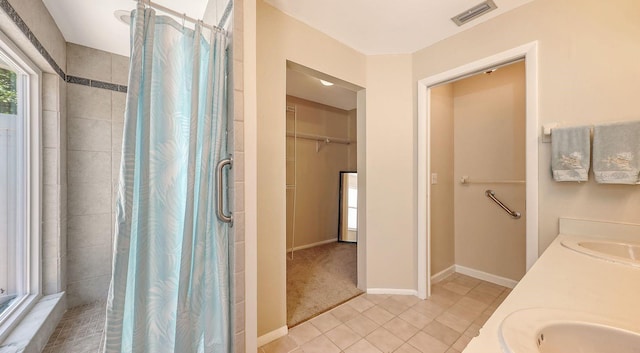 4308 Kingston Loop, Sarasota, FL 34238 - full bathroom featuring tiled shower, tile patterned floors, double vanity, a spacious closet, and baseboards