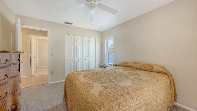 4308 Kingston Loop, Sarasota, FL 34238 - bedroom featuring baseboards, light carpet, a closet, ceiling fan, and light tile patterned floors