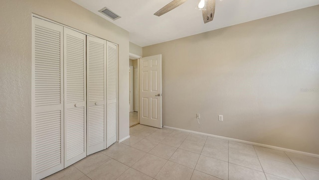 4308 Kingston Loop, Sarasota, FL 34238 - unfurnished bedroom with a closet, baseboards, ceiling fan, and light tile patterned flooring