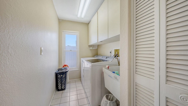 4308 Kingston Loop, Sarasota, FL 34238 - laundry area featuring cabinet space, washing machine and dryer, light tile patterned floors, a textured wall, and baseboards