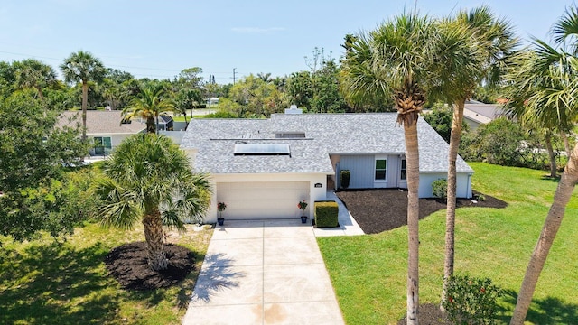 4308 Kingston Loop, Sarasota, FL 34238 - view of front of property with a shingled roof, a front yard, concrete driveway, an attached garage, and a chimney