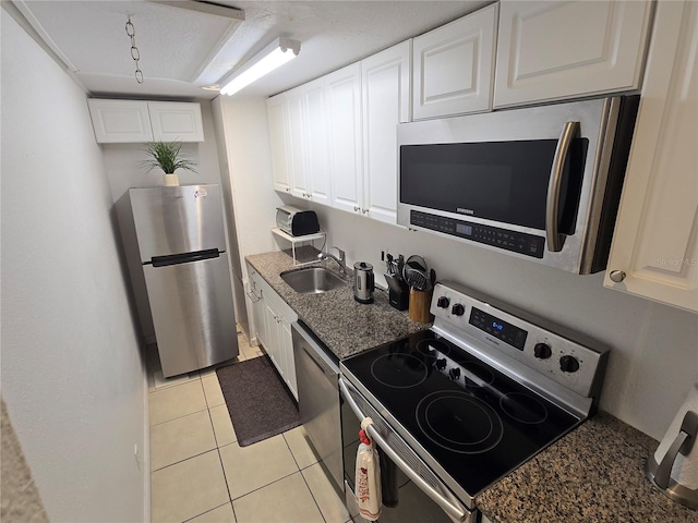 4213 E Michigan St Unit 4213, Orlando, FL 32812 - kitchen featuring appliances with stainless steel finishes, a sink, white cabinets, and light tile patterned floors