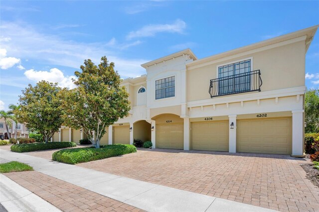 4204 Overture Cir # 4204, Bradenton, FL 34209 - view of front of home featuring a garage, driveway, a balcony, and stucco siding