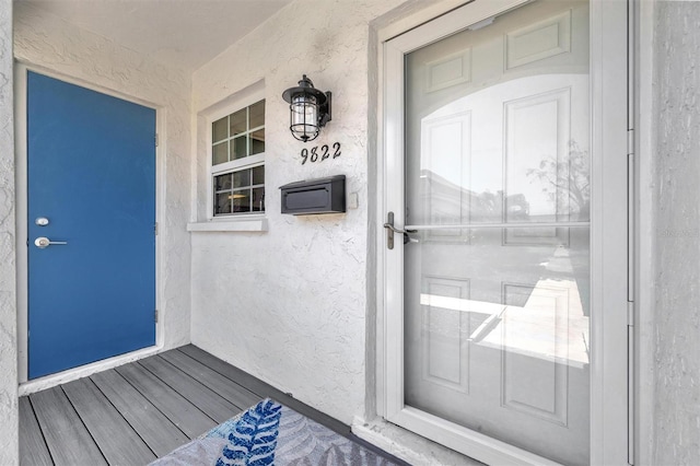 9822 Desoto Ct, Bradenton, FL 34210 - view of exterior entry featuring stucco siding and a porch
