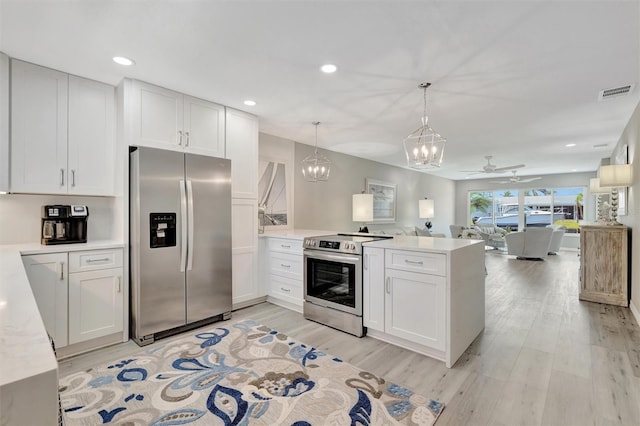 9822 Desoto Ct, Bradenton, FL 34210 - kitchen with appliances with stainless steel finishes, a peninsula, open floor plan, light countertops, and white cabinetry