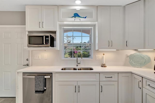 9822 Desoto Ct, Bradenton, FL 34210 - kitchen with appliances with stainless steel finishes, a sink, white cabinetry, and light countertops