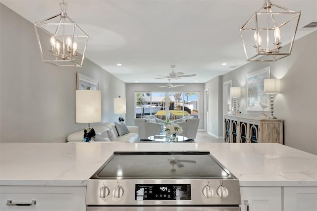 9822 Desoto Ct, Bradenton, FL 34210 - kitchen with a chandelier, stainless steel range with electric stovetop, open floor plan, light stone countertops, and recessed lighting