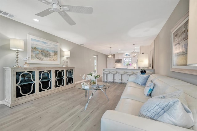 9822 Desoto Ct, Bradenton, FL 34210 - living area featuring light wood-style flooring, baseboards, ceiling fan, recessed lighting, and a chandelier