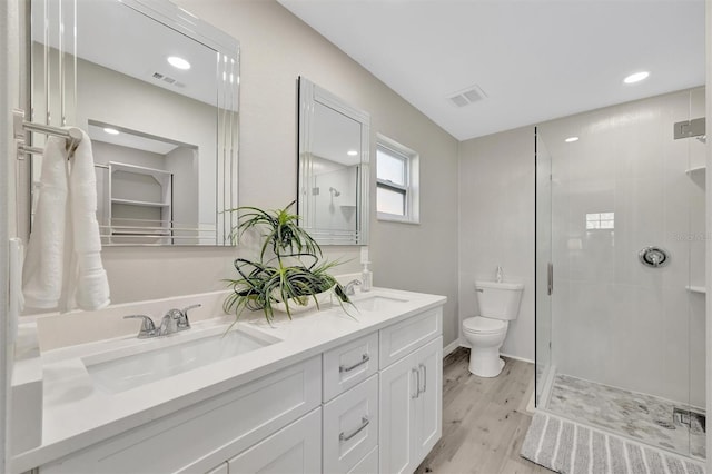 9822 Desoto Ct, Bradenton, FL 34210 - full bathroom featuring toilet, double vanity, wood finished floors, a stall shower, and recessed lighting