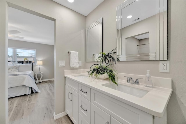 9822 Desoto Ct, Bradenton, FL 34210 - ensuite bathroom with wood finished floors, double vanity, and baseboards