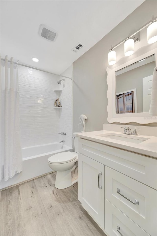 9822 Desoto Ct, Bradenton, FL 34210 - bathroom with vanity, shower / tub combo with curtain, toilet, wood finished floors, and recessed lighting